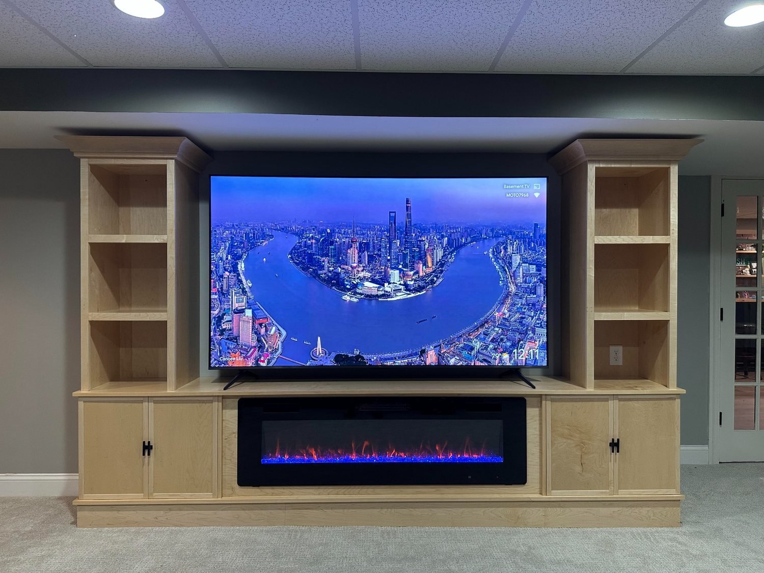 Completed maple entertainment center with television and fireplace