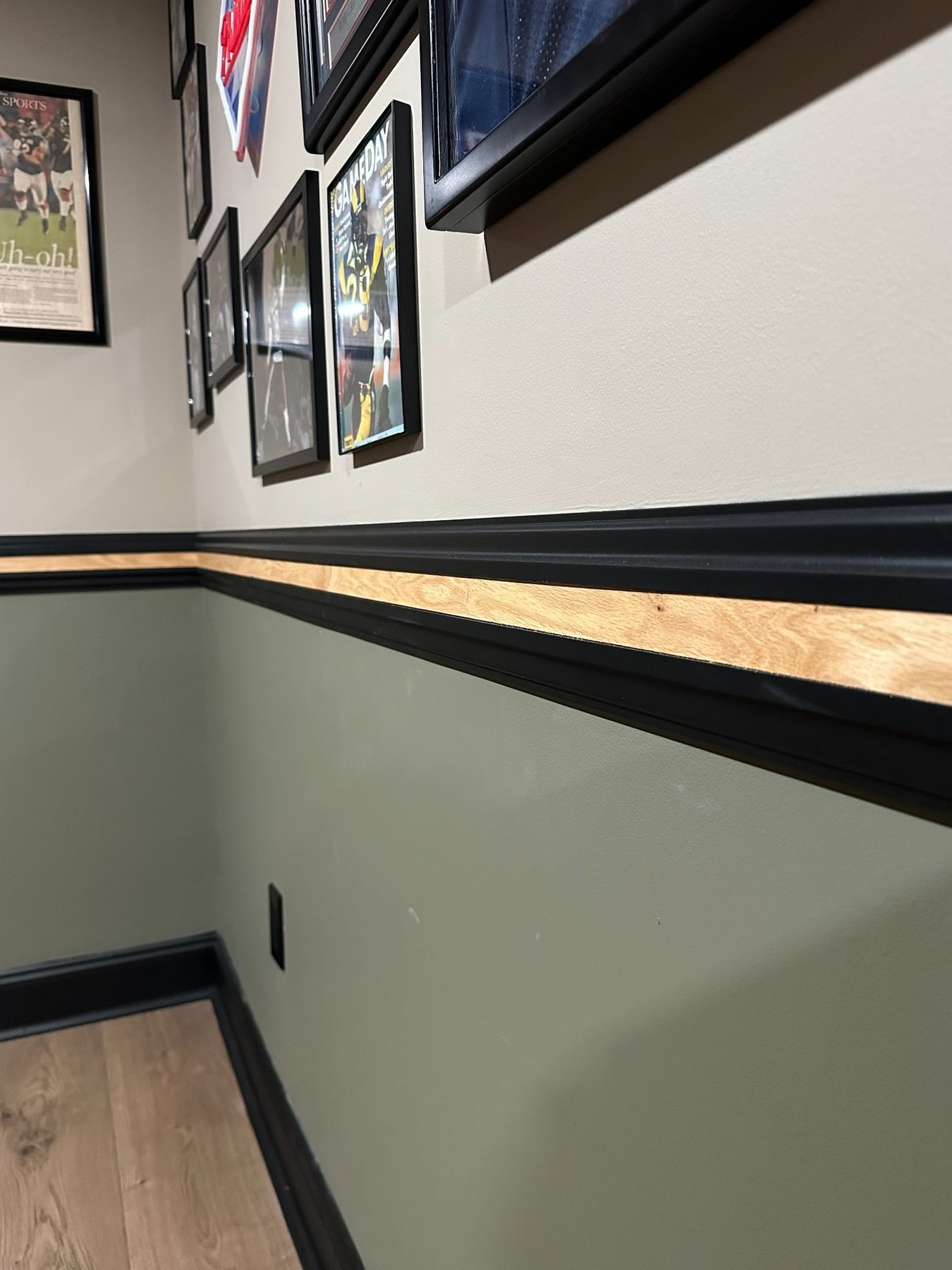 Close-up of black chair rail with natural wood accent strip