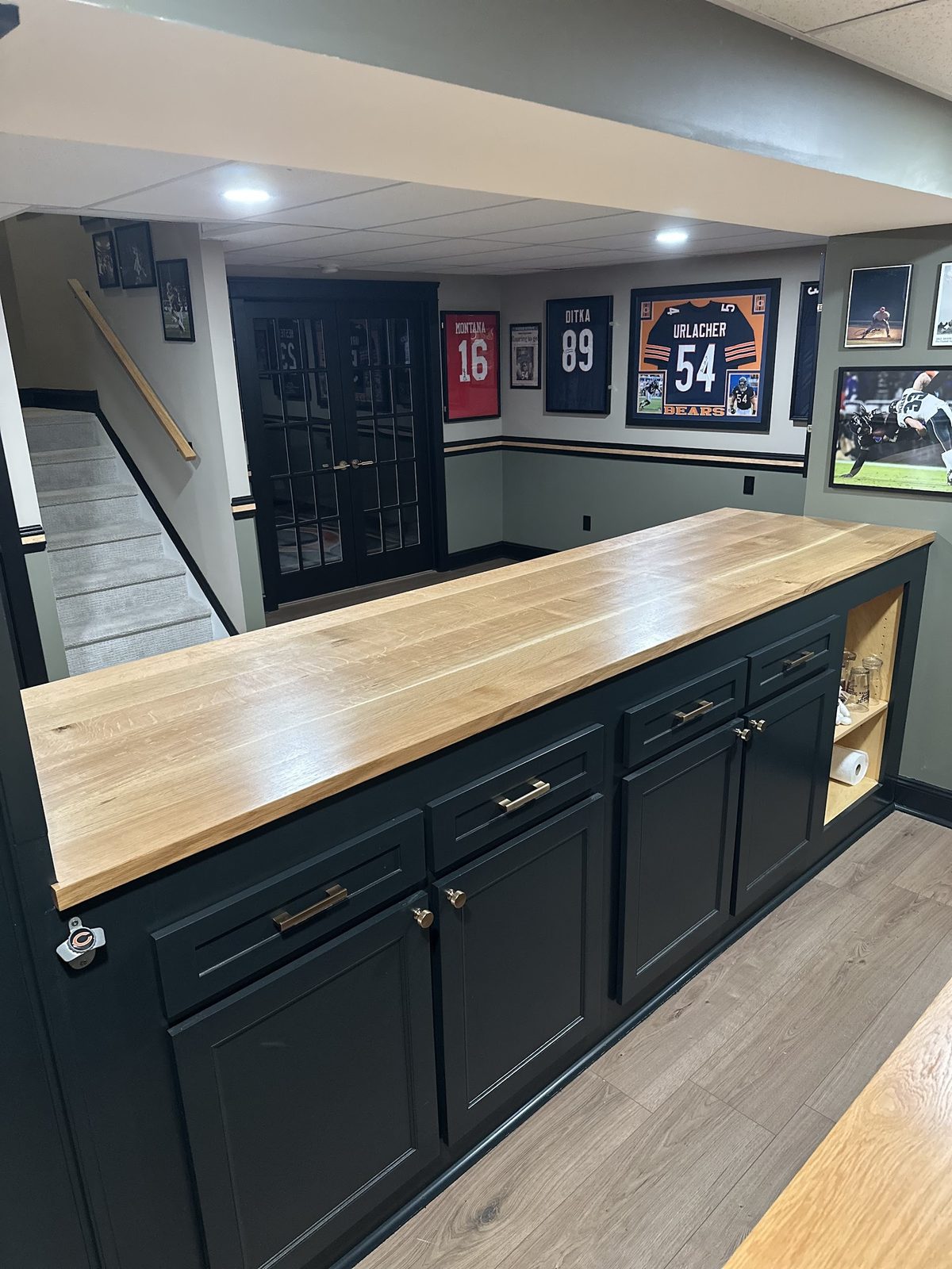 Back side of custom bar cabinetry with oak top