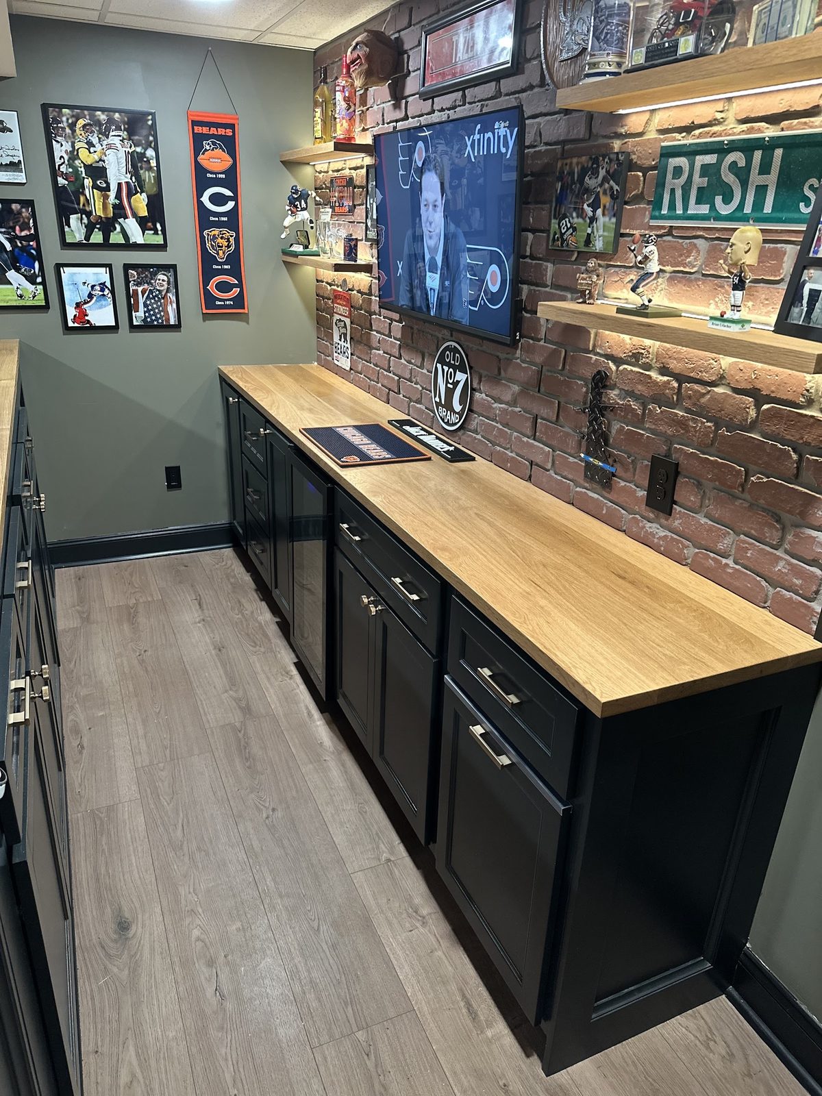 Black cabinetry and oak countertop in basement bar